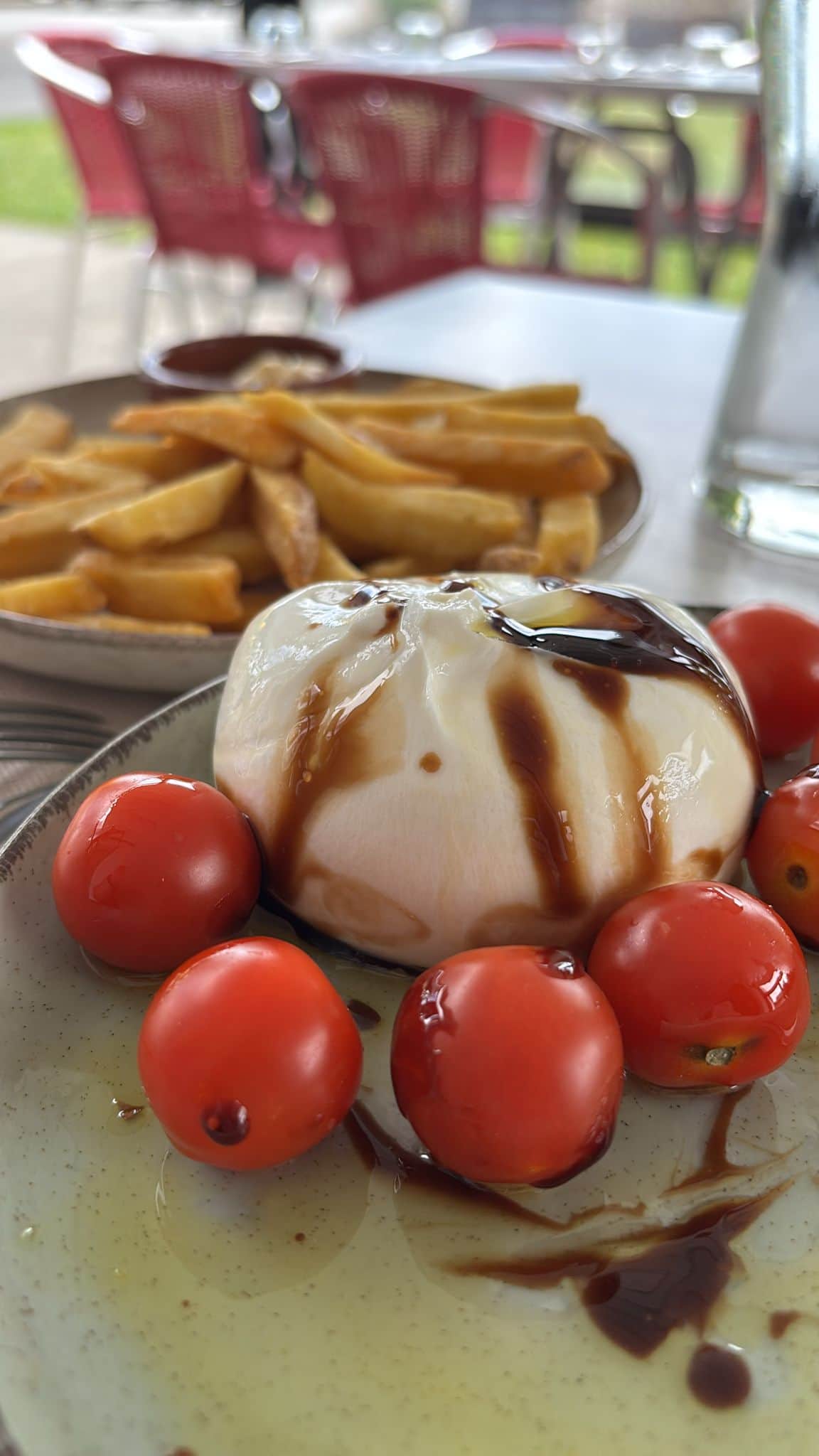 Burrata servie avec tomates cerises et frites en terrasse au B Brasserie